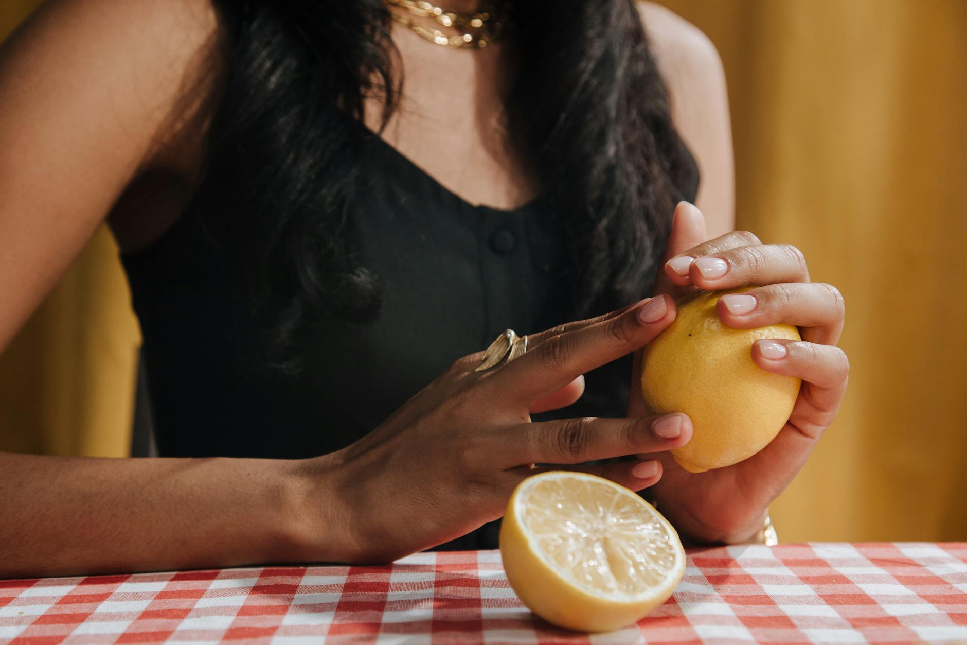 Hand holding an orange vibrator against a minimalistic purple backdrop, showcasing modern intimacy solutions