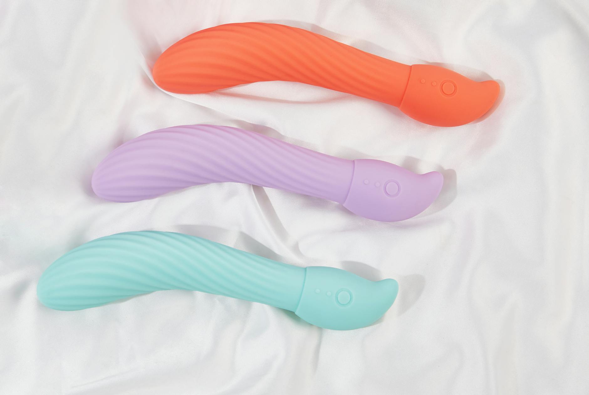 Three colorful lemon vibrators and traditional vibrators arranged on white fabric, showing different toy designs side by side.