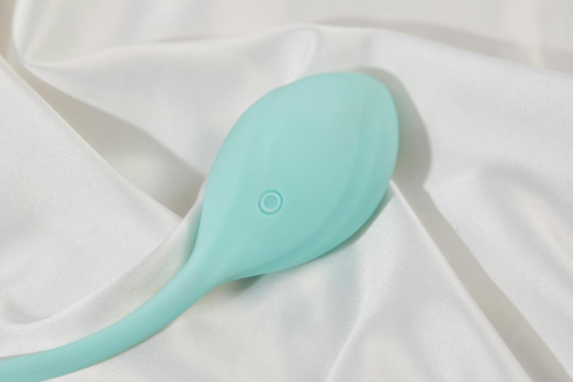 Hand holding a vibrator against a soft purple backdrop