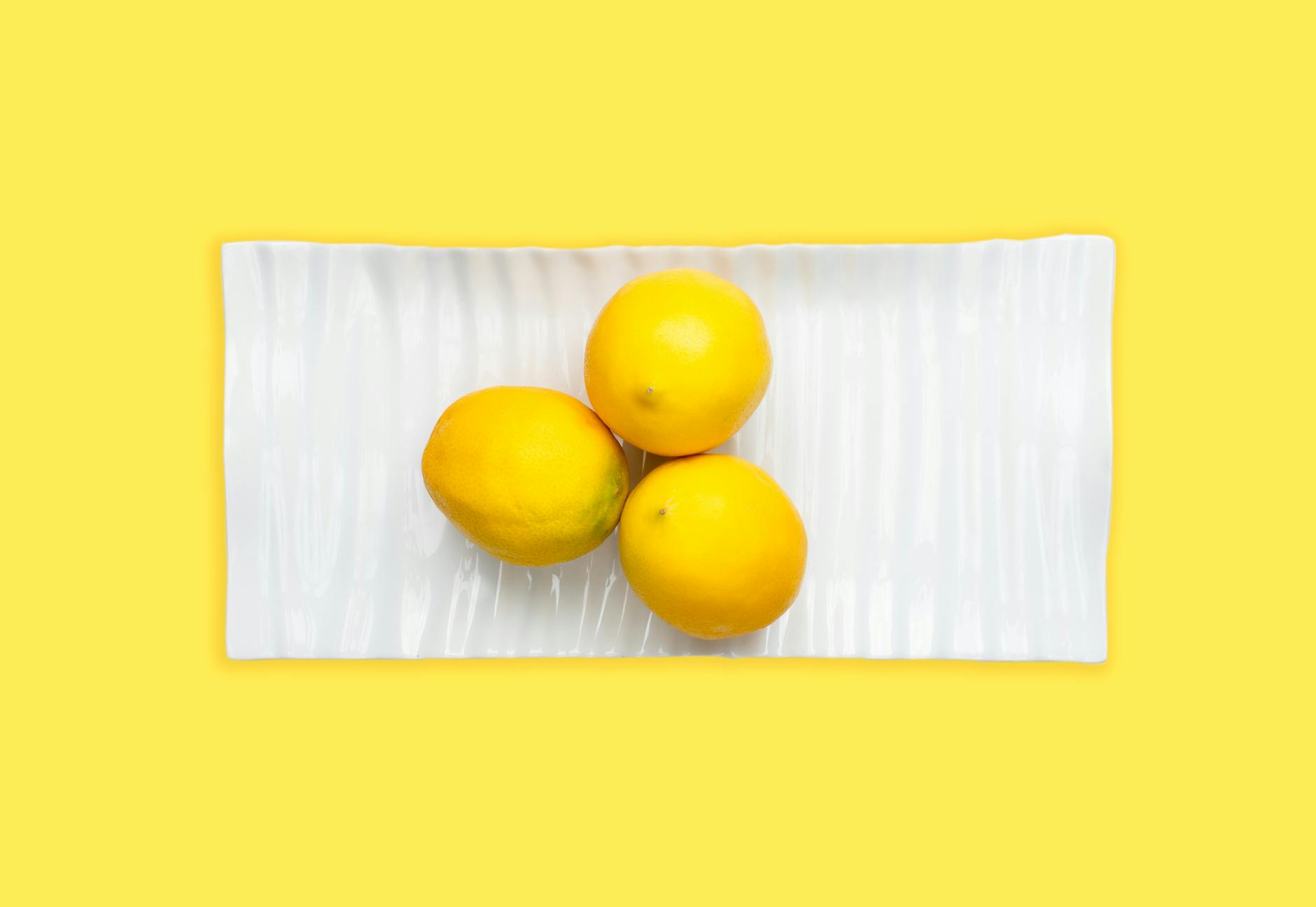 Bright yellow lemons on a soft pastel green background, representing fresh perspective and renewal