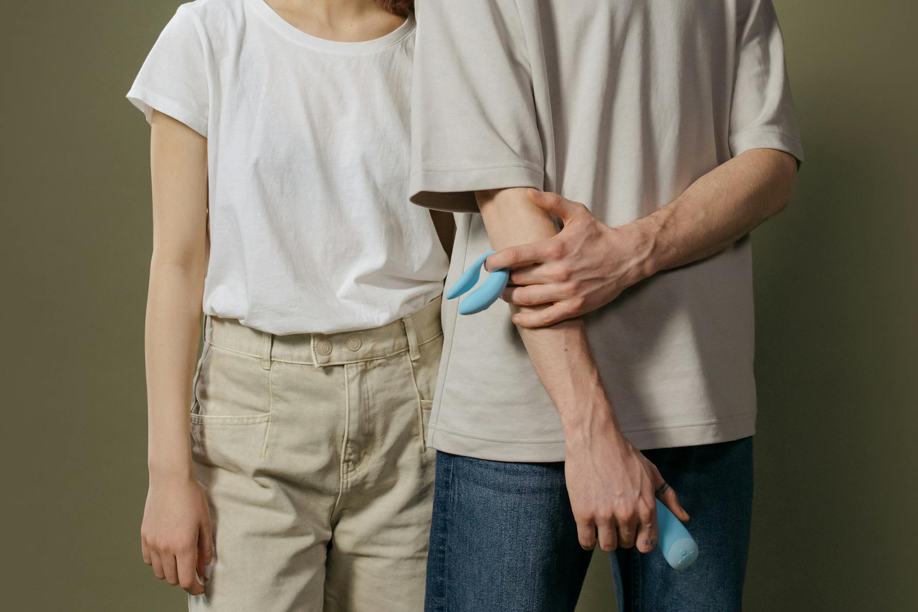 Young couple embracing while exploring intimacy together with modern pleasure devices